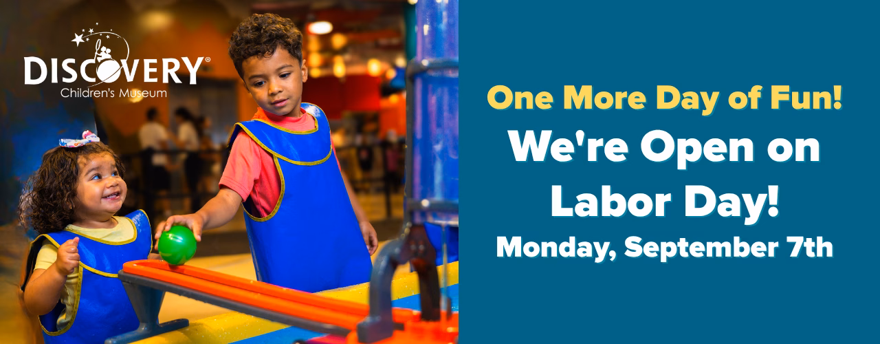 Banner graphic announcing DISCOVERY Children's Museum is open on Labor Day, Monday, September 7th, featuring two young children playing at a museum exhibit.