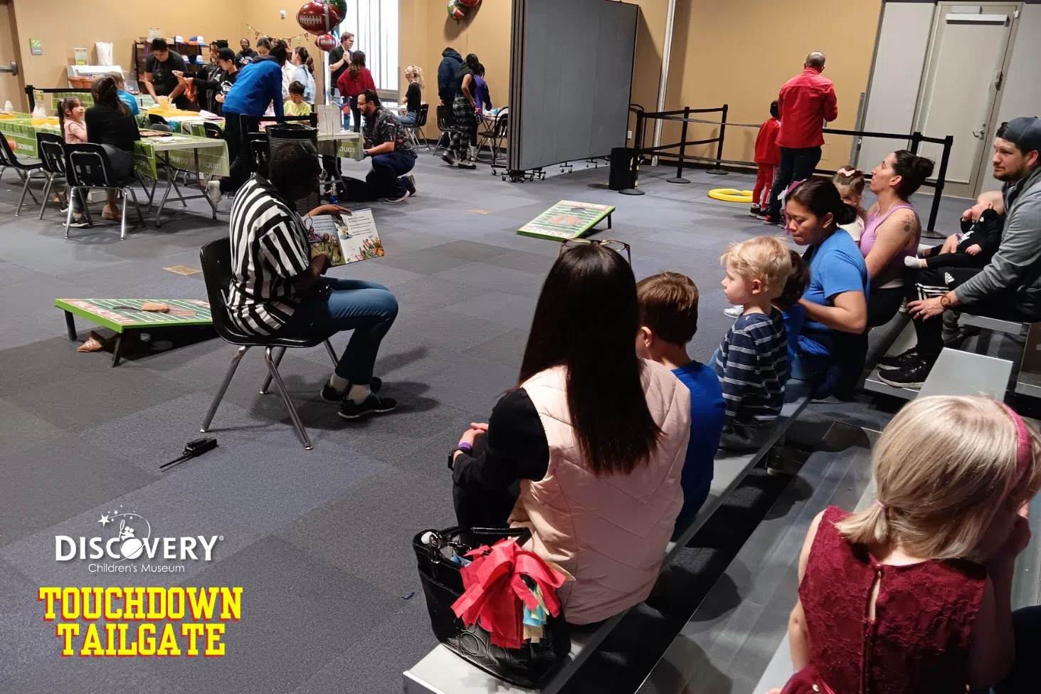 woman reading a storybook to a group of children at the Discovery Children's Museum