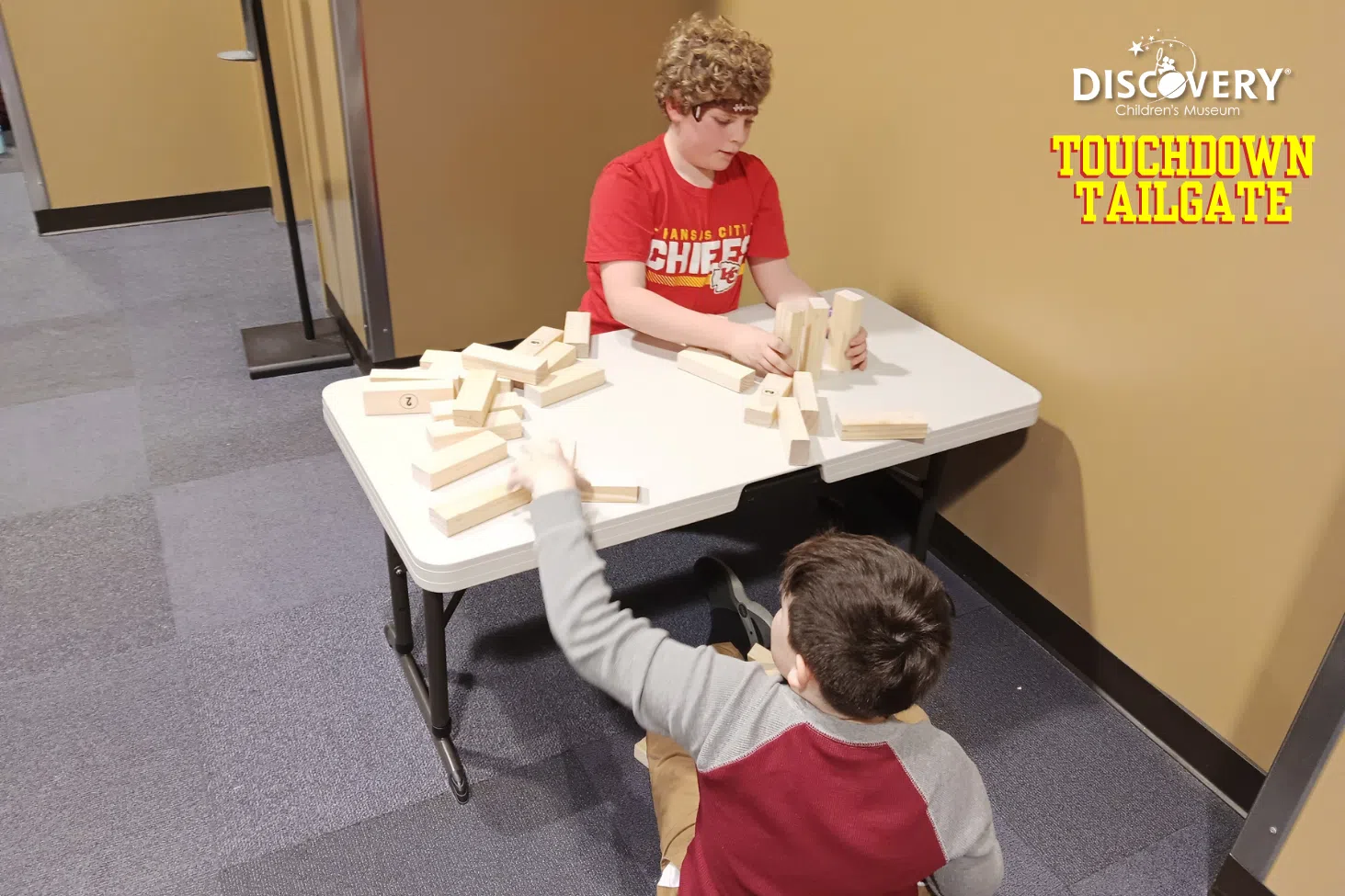 2 children standing up wooden blocks at a table at the Discovery Children's Museum